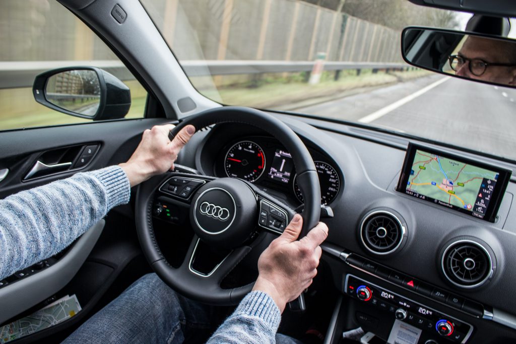 hands on a steering wheel in automobile