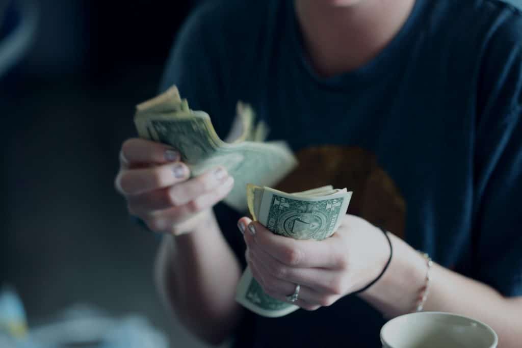 woman counting dollar bills after a car accident