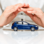 Auto insurance attorneys hand covering a toy car