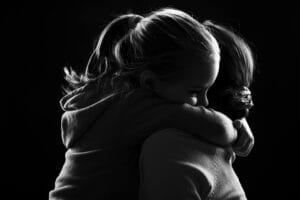 Sad girl hugging her mom